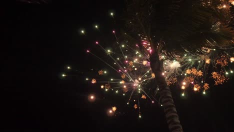 Fireworks-exploding-in-the-sky-at-a-tropical-beach-in-mexico