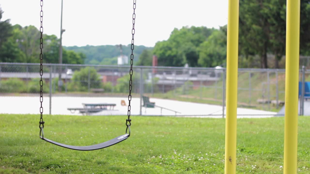 Static shot of a swing moving in a park