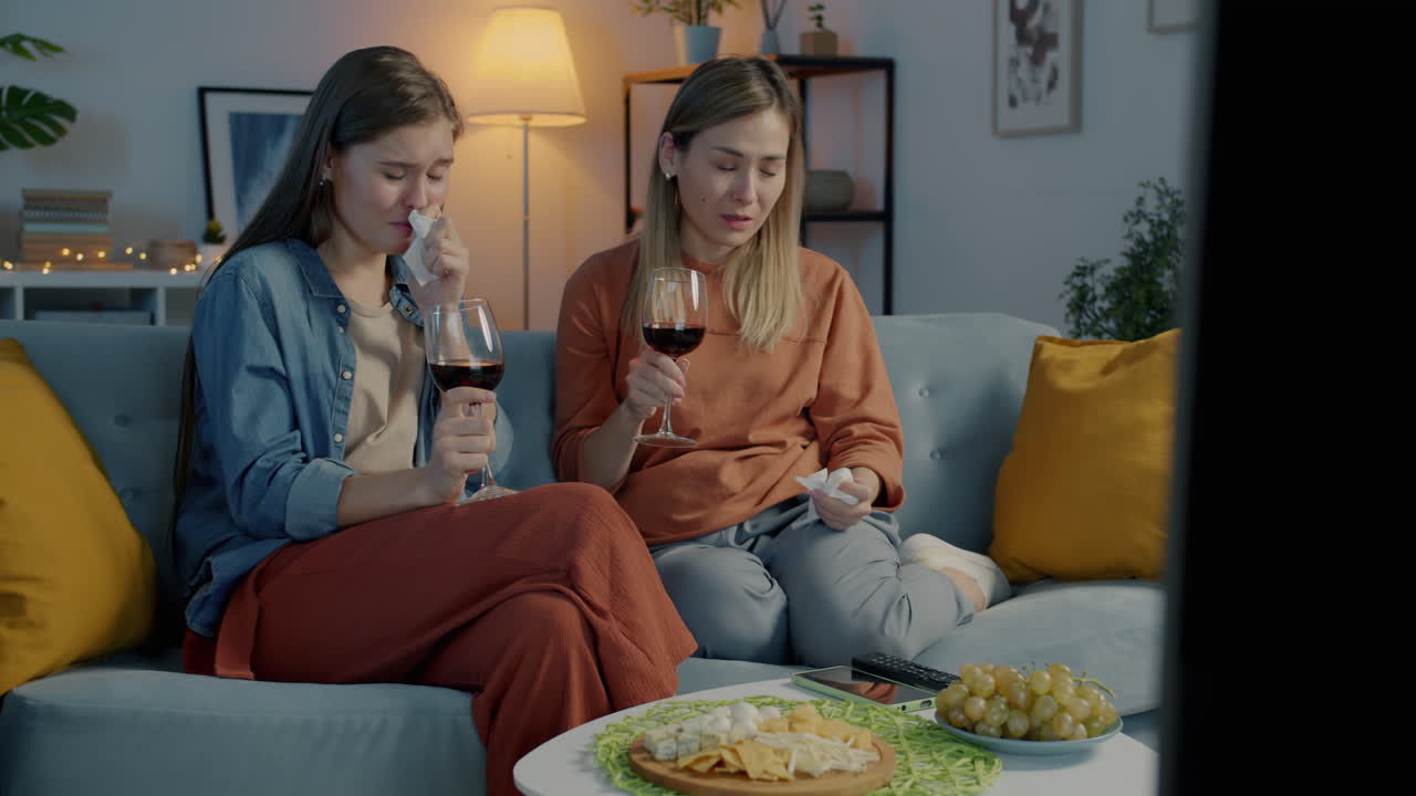 Two women watching a sad movie/series together