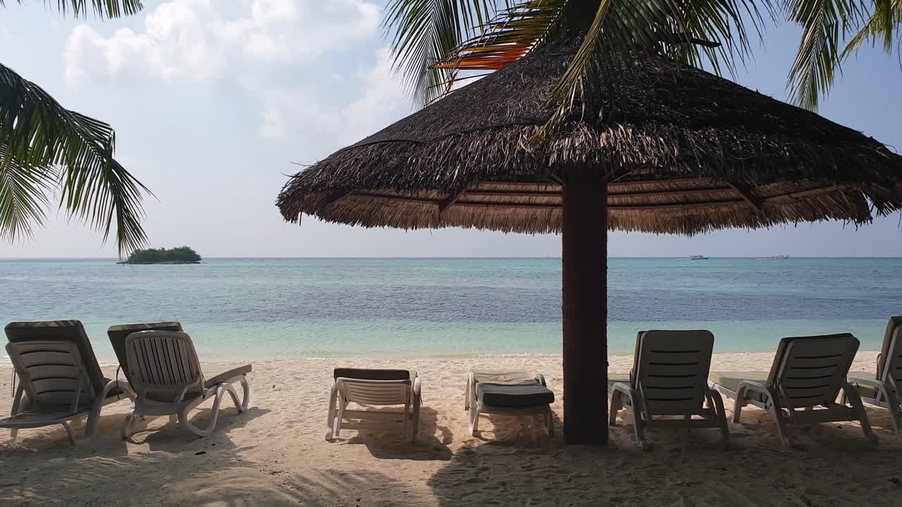First person pov walk towards beach chairs and umbrella in Maldives