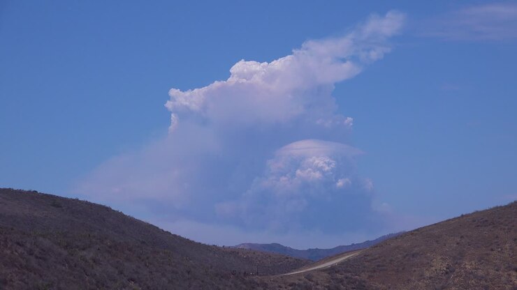 A timelapse shot of smoke rising in a huge mushroom cloud as a wildfire rages