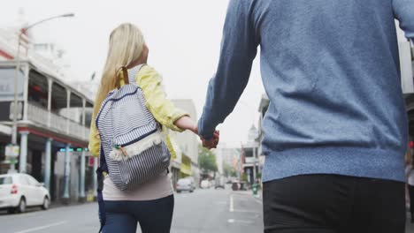 vista trasera de una pareja caucásica en movimiento durante la pandemia de coronavirus