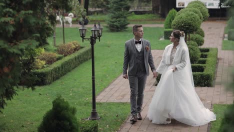 Lovely-newlyweds-caucasian-bride-groom-walking-in-park,-holding-hands,-wedding-couple-family