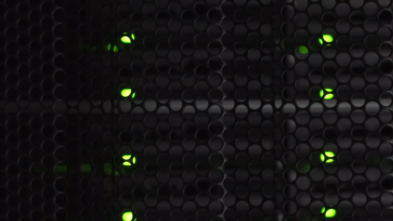 puntos de computadora detrás de un gabinete de acero con diseño de peine de abeja iluminador en una sala de servidores