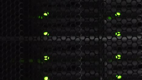 puntos de computadora detrás de un gabinete de acero con diseño de peine de abeja iluminador en una sala de servidores