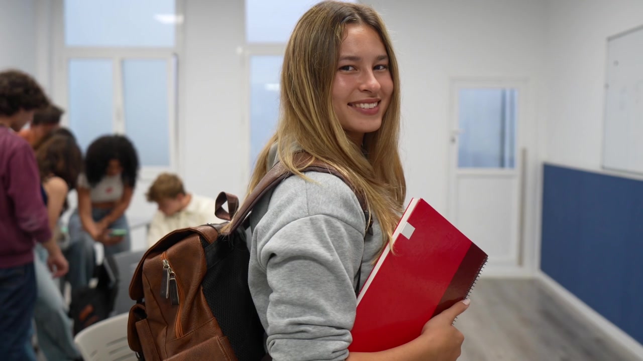 Šťastná mladá studentka se usmívá v učebně