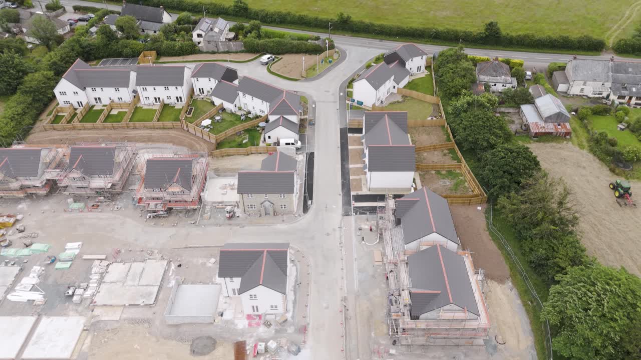 Aerial view of a new housing development in a rural village in Devon, UK, showing construction and completed houses