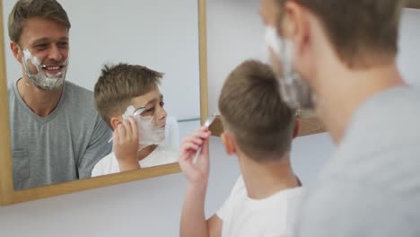 Hombre-Caucásico-Y-Su-Hijo-En-El-Baño-Con-Espuma-De-Afeitar-En-La-Cara-Y-Sonriendo