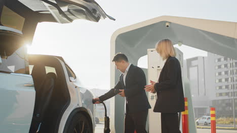 personas de negocios cargando un vehículo eléctrico
