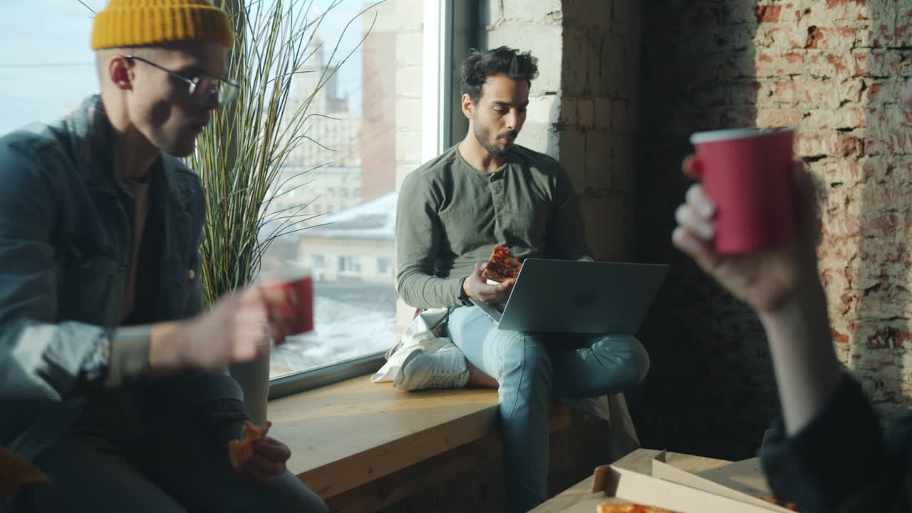 Friends Enjoying Pizza Lunch by the Window
