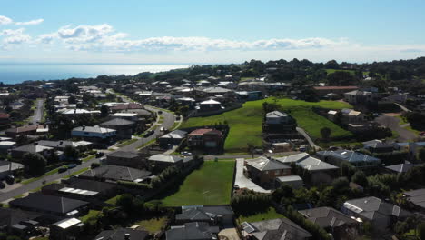 aerial housing estate in coastal town with vacant lots on sunny day