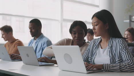students working on laptops in a classroom