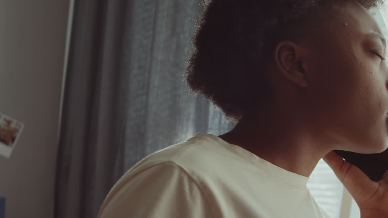 African American Woman Chatting on Phone at Home