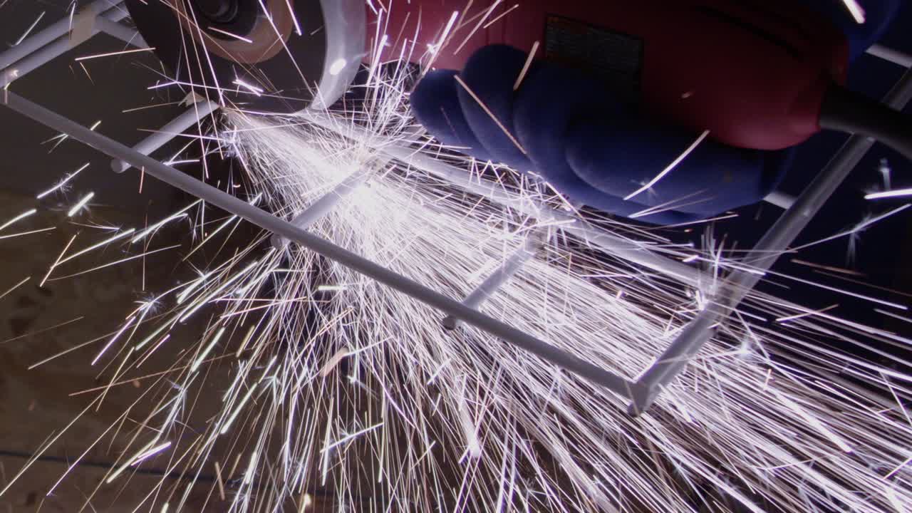 절단 디스크로 강철 랙을 절단하는 동안 밝은 불꽃이 생성됩니다.