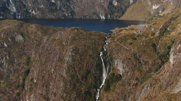 4k daytime video with a high waterfall stream being revealed in the Peruvian Andes - 5 Lakes (Lagoons) of Pichgacocha, Ambo, Huanuco. Boom-jib down, wide angle shot.