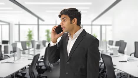 angry indian businessman shouting on someone on phone
