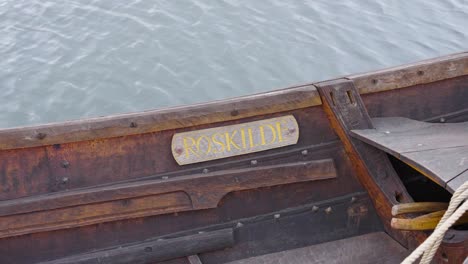 name tag attached on vintage wooden boat floating on water, denmark