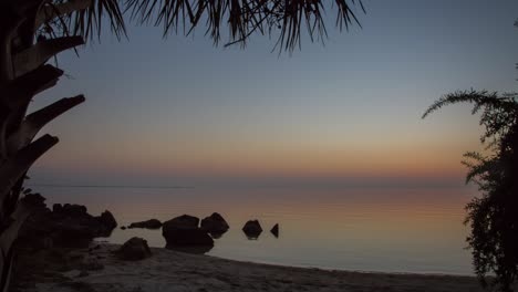 Die-Sonne-Versinkt-Am-Horizont-Am-Tropischen-Sandstrand,-Zeitraffer-Von-Tag-Zu-Nacht