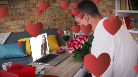 iconos de corazón rojo sobre hombre caucásico sosteniendo un ramo de flores mientras hace una videollamada en una computadora portátil
