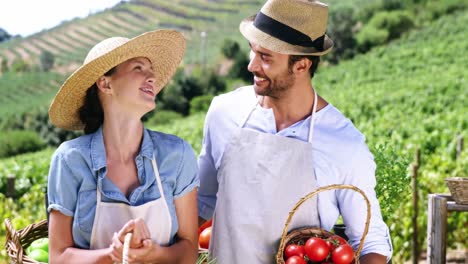 pareja feliz sosteniendo verduras frescas en la canasta