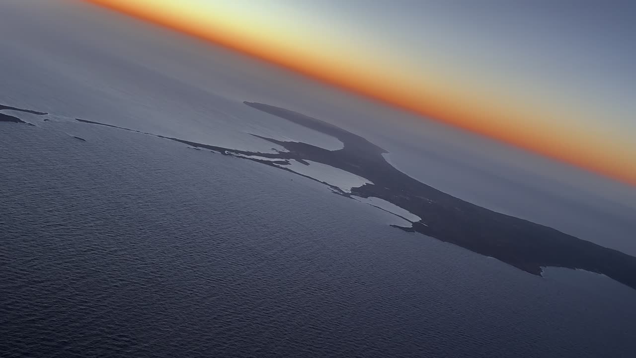 Veduta aerea dell'isola di Formentera catturata dalla cabina di pilotaggio di un aereo durante una virata a sinistra sul Mar Mediterraneo all'alba con un orizzonte dorato