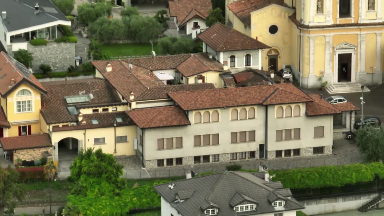 Colorful buildings and lush gardens near lake iseo, italy, aerial view