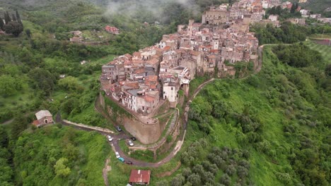 Aerial-reveals-beautiful-town-surrounded-by-misty-clouds-and-green-hills