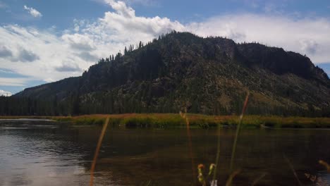 Amplia-Vista-Panorámica-De-Una-Montaña-Cubierta-De-árboles-Sobre-Un-Lago