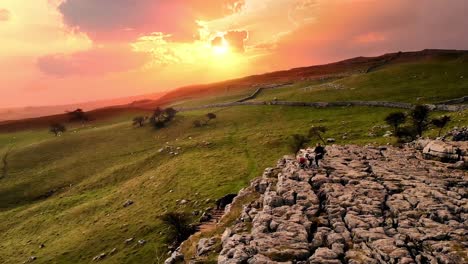 sunset drone shot flying over drummer playing on rocks at malham cove