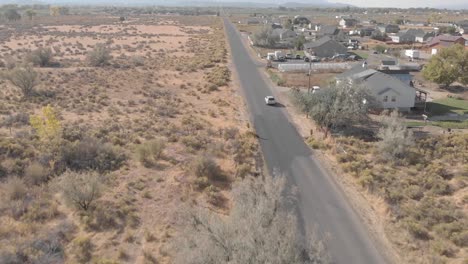 Drone-shot-car-driving-through-small-town-near-Zion-National-Park