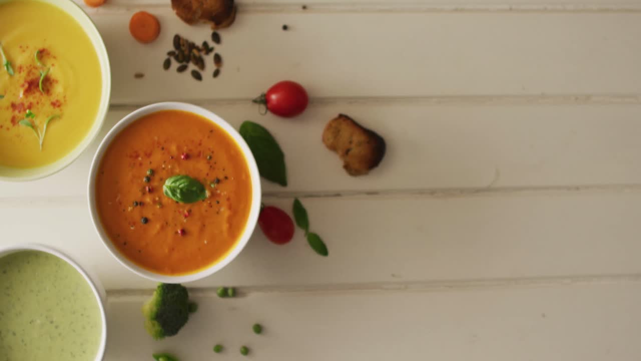 video de diversas sopas de verduras de crema con ingredientes sobre una superficie blanca