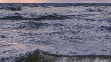 waves at sea during a thunderstorm at sunset