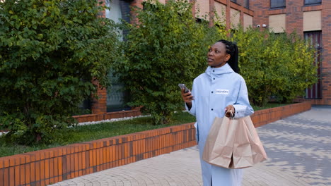 young woman holding paper bags on the street