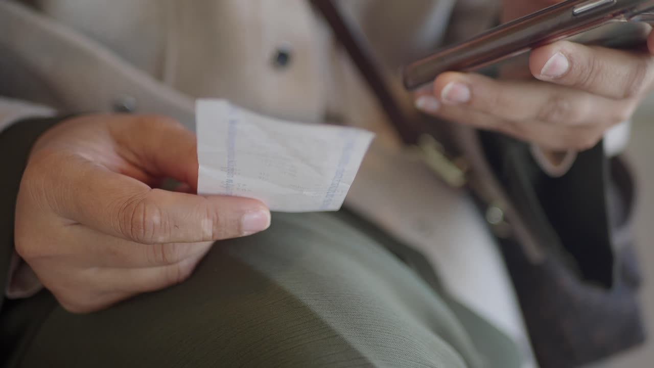 Person reading a receipt with a cell phone