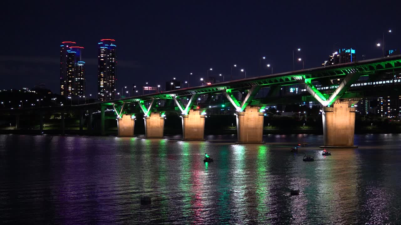 Lights Blinking From Duck Boat At Han River With Cheongdam Bridge And Seoul City In The Background In South Korea. - wide shot