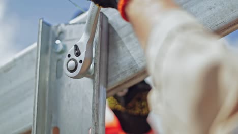 metal frame installation. hand of a worker is fixing metal basis for photovoltaic solar panel. close-up.