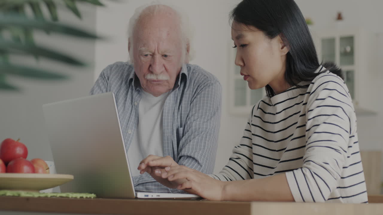 Senior man and woman learning on laptop