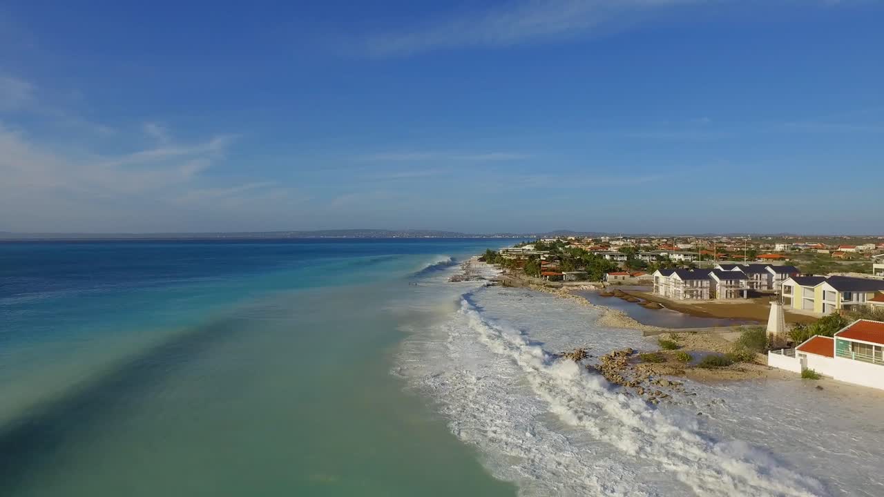 grandes olas dañando casas después de que un huracán pasara por la costa de bonaire