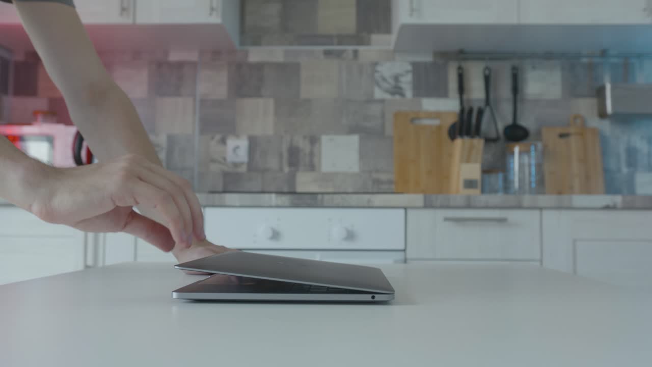 persona abriendo una computadora portátil en una cocina