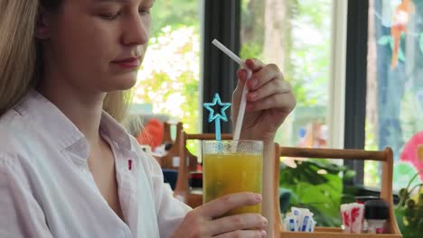 una mujer disfrutando de una copa en un café.