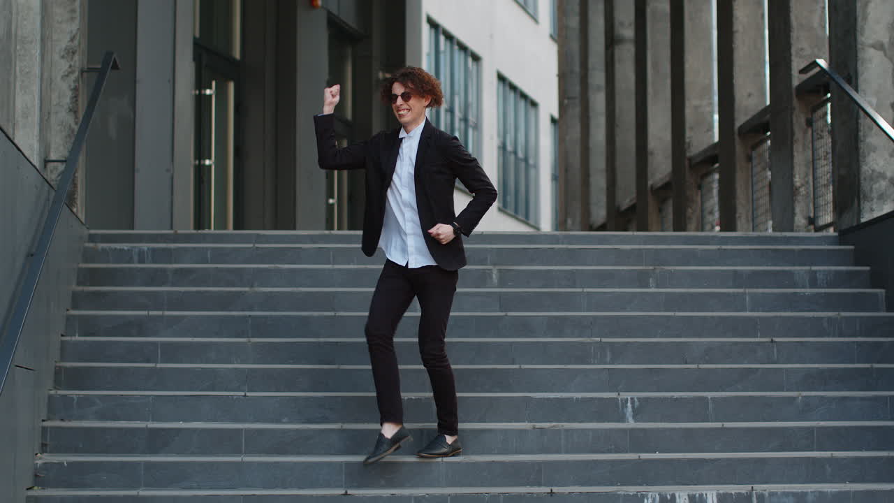 empresario emocionado celebrando en los escalones caminando después de una entrevista de trabajo promoción bailando éxito