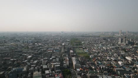 aerial scenic urban drone footage of a neighborhood, streets and buildings in the capital city of tokyo, japan during sunset