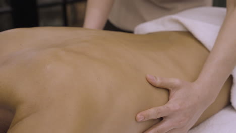 Therapeutic-Lower-Back-Massage-Close-Up,-Professional-Female-Therapist-Back-Pain-Massage-Therapy,-Relaxation-Spa,-Wellness-Aromatherapy-Hot-Oil-Massage