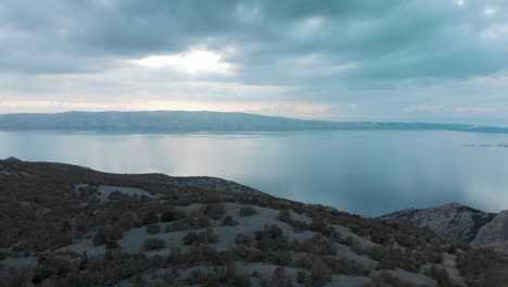 Aerial-pan-shot-over-rocky-seashore-and-islands-in-cloudy-day