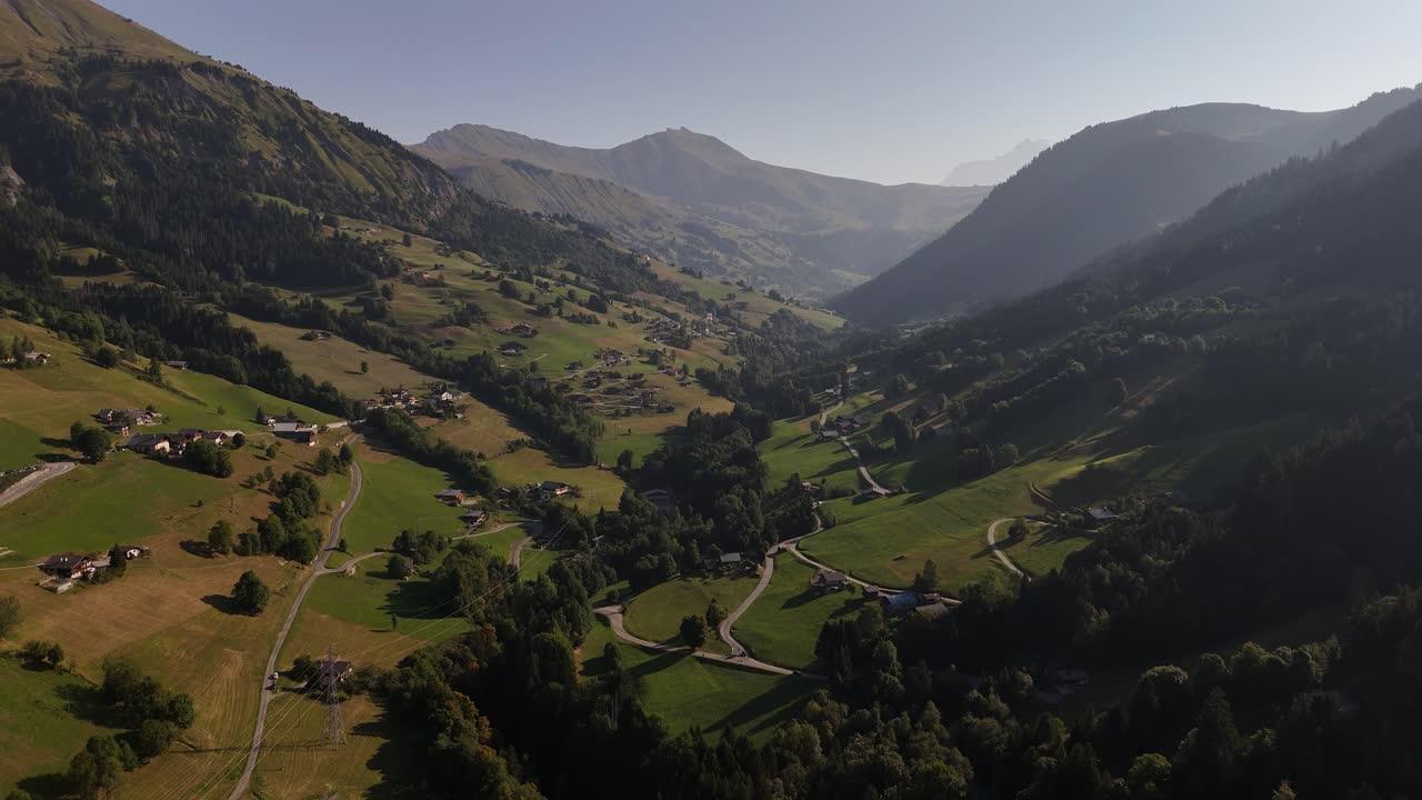 Drone flying sideways over a mountain valley at sunrise in 4k