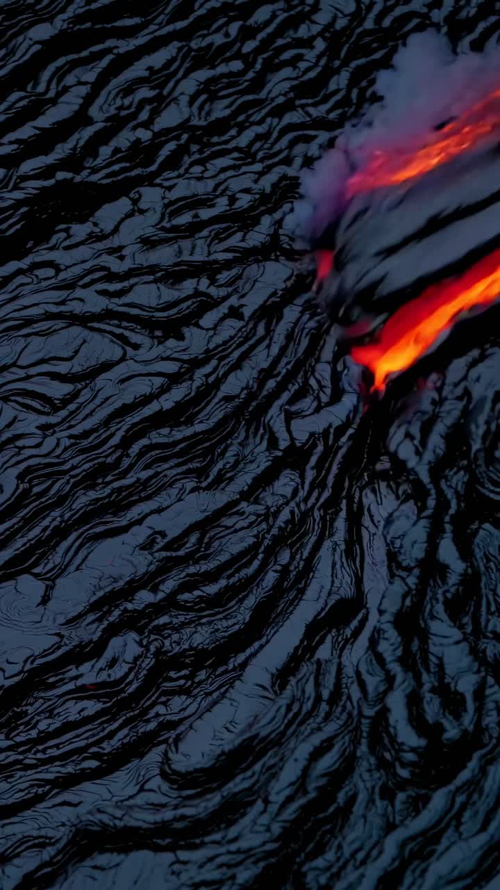 Aerial view of vibrant lava flow over dark, textured surface, capturing the dynamic and mesmerizing