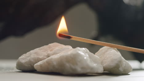 Person holding Palo Santo wood stick in hand, aromatic Palo Santo burning on black background, smoke spreading around, slow motion video clip, high quality 4k close up footage. High quality 4k footage