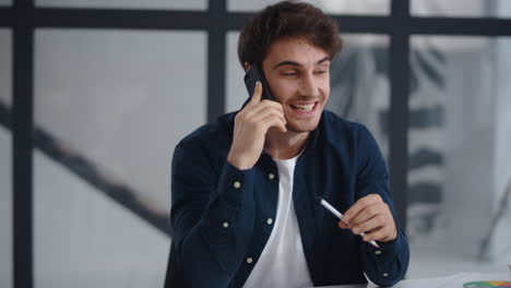 Hombre-De-Negocios-Sonriente-Hablando-Por-Teléfono-Móvil-En-La-Oficina.-Chico-Terminando-Llamada-Telefónica