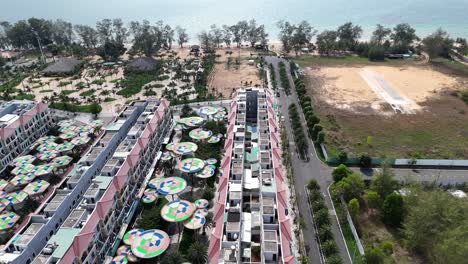 an aerial video evening presents a newly built town with a style wide roads, colorful buildings. emerging green spaces are evident a beautiful sandy beach meeting the blue sea.
