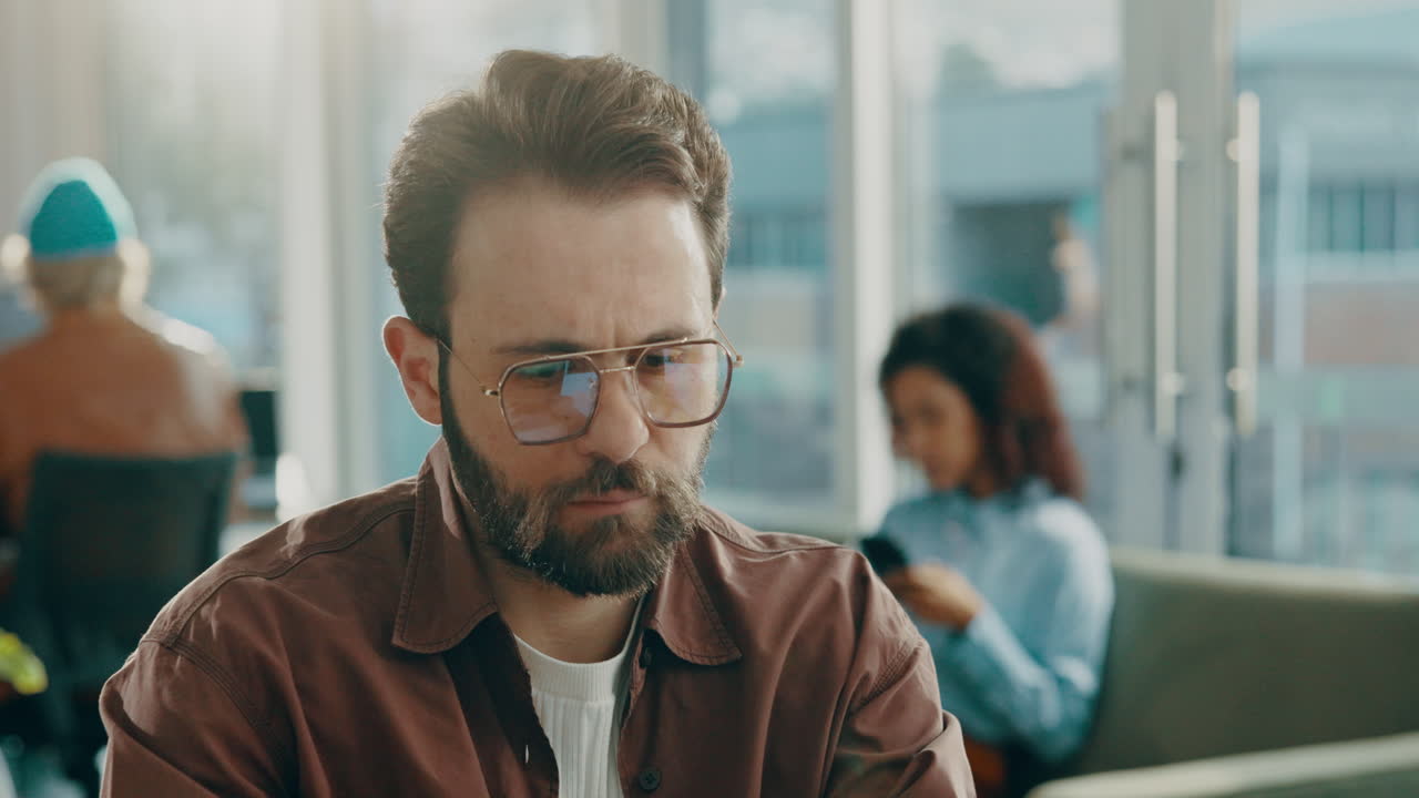 Ritratto di un uomo con occhiali e barba in un ufficio